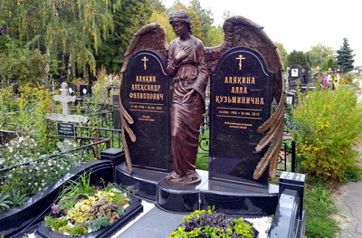 Охватывающая оба надгробья широкими крыльями скульптура ангела